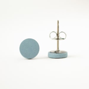 May include: A pair of light blue round stud earrings with silver posts and butterfly backs.