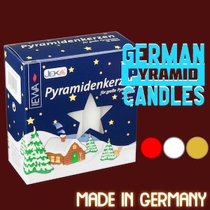 May include: A box of white pyramid candles with a winter scene on the front. The box is labeled "German Pyramid Candles" and "Made in Germany".