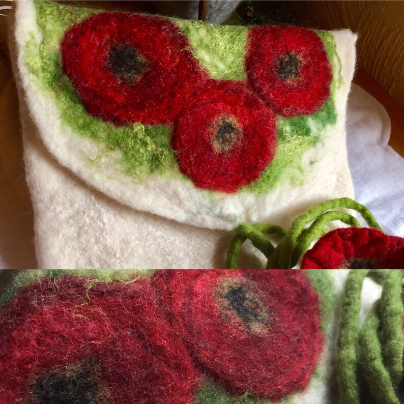 May include: A white felt bag with a flap closure and a drawstring. The bag is decorated with three red felt poppies with black centers. The bag has a green felt trim.