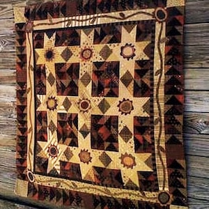 Peut inclure: Une courtepointe patchwork de couleur marron, beige et blanche avec un motif d'étoile et une bordure de vigne. La courtepointe est faite de différents tissus et textures.