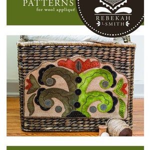 May include: A wool applique pattern for a wildflower design in a basket. The pattern is called "Wild Flower Wooly" and is 15 inches wide by 9 1/4 inches high. The pattern is by Rebekah L. Smith.