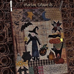 May include: A handmade quilt block featuring a witch with a black cat, a cauldron, and pumpkins. The quilt block is made with a variety of fabrics in brown, black, green, and red. The text "Witchy Hollow... by... Marian Edwards" is stitched on the top of the quilt block.