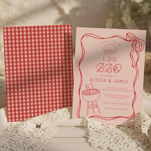 May include: Pink BBQ wedding invitation with red text and a red gingham pattern on the back. The invitation includes the text "I DO BBQ" and details for Alyssa & James' wedding, including the date, time, and location.