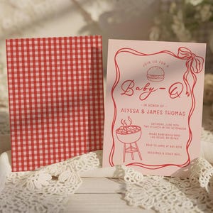 以下が含まれることがあります： 「Baby-Q」の文字と赤い縁取りが入ったピンク色のベビーシャワー招待状。Alyssa & James Thomasの詳細、日付、時間、場所が含まれています。裏面には赤と白のチェック柄があります。