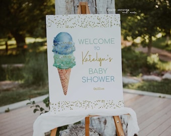 May include: Welcome to Katelyn's Baby Shower sign with a watercolor ice cream cone illustration. The sign is white with gold glitter accents and blue and green text. The date 06.03.xx is printed at the bottom.