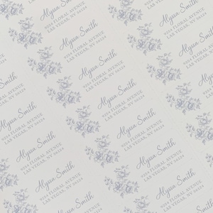 May include: A sheet of white paper with multiple blue floral designs and the text "Alyssa Smith 9254 Floral Avenue Las Vegas, NV 56124" repeated throughout.