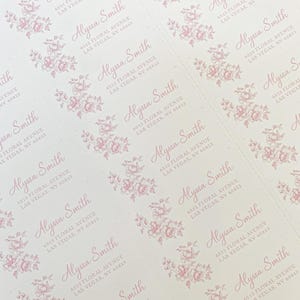 May include: A sheet of white return address labels with a pink floral design. The labels have the text "Alyssa Smith" and the address "6513 Floral Avenue, Las Vegas, NV 65813" printed on them.