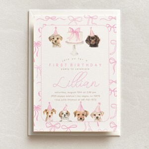 May include: Pink and white first birthday party invitation with a pink bow pattern. The invitation features a watercolor illustration of a cake and four dogs wearing party hats. The text reads "Join us for a First Birthday party to celebrate Lillian. Saturday, August 10th at 2:00 pm. 3925 Puppy Avenue | Las Vegas, NV 15975. RSVP Julie Thomas at 681-961-1572."