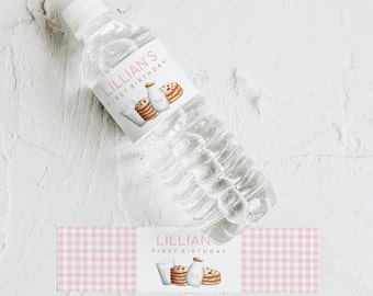 May include: Water bottle label with a pink and white gingham pattern. The label features a milk carton, cookies, and a glass of milk. The text on the label reads "Lillian First Birthday".