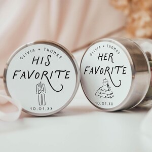 May include: Two small, round, silver-lidded containers with white labels. One reads "Olivia + Thomas HIS FAVORITE" with a tuxedo illustration. The other says "Olivia + Thomas HER FAVORITE" with a wedding dress illustration. Both have a date.