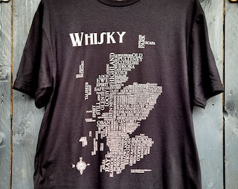 May include: Black t-shirt with a white print of a map of Scotland. The map is made up of words related to whisky, including distillery names, regions, and types of whisky. The word "WHISKY" is printed at the top of the shirt.