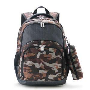 May include: A camouflage-patterned backpack with a matching pencil case. The backpack features a large main compartment, a front pocket, and a top handle. The color scheme includes shades of brown, gray, and tan. The backpack has silver zippers.