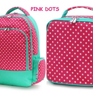 May include: Pink polka dot backpack and lunch bag set. The backpack has a large main compartment, a front pocket, and adjustable straps. The lunch bag has a zipper closure and a handle.