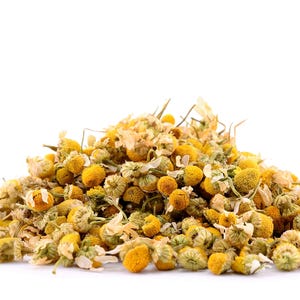 May include: A pile of dried chamomile flowers, a popular herbal tea ingredient, with a light yellow color.