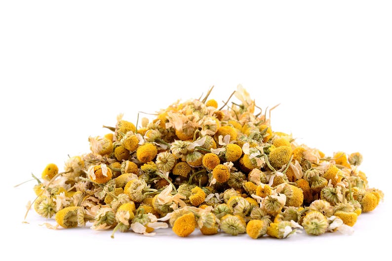 May include: A pile of dried chamomile flowers, a popular herbal tea ingredient, with a light yellow color.