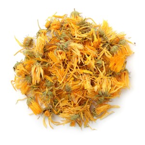 May include: Dried calendula petals, a vibrant yellow-orange color, are scattered in a loose pile. The petals are dried and have a slightly crinkled texture.