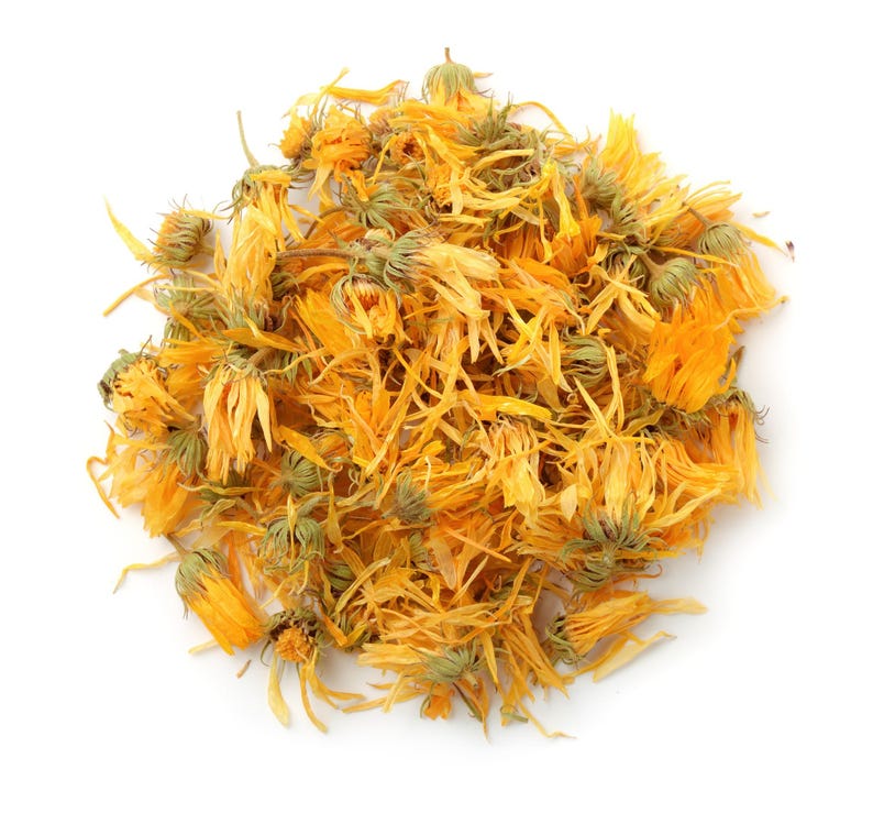 May include: Dried calendula petals, a vibrant yellow-orange color, are scattered in a loose pile. The petals are dried and have a slightly crinkled texture.