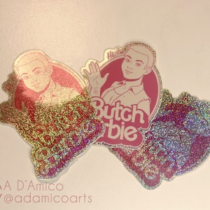 May include: Three holographic stickers featuring a cartoon illustration of a person with the text "Hi I'm Butch Barbie".