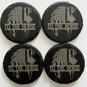 May include: Set of four black slate coasters with a gray horse silhouette and American flag design. Each coaster features the text "To the Horse".