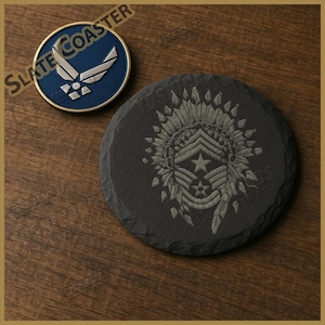 May include: A circular slate coaster featuring an engraved design of a military rank insignia within a feathered headdress. Beside it sits a round blue and silver emblem displaying the United States Air Force logo with the text SLATE COASTER.