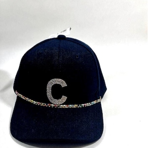 May include: A black baseball cap with a curved brim. The cap features a large, sparkling letter "C" made of rhinestones. A band of colorful beads encircles the base of the cap, adding a touch of flair. The cap is set against a white background.