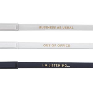 May include: Three slim pens with rectangular caps. The top pen is light gray with gold text reading BUSINESS AS USUAL. The middle pen is white with gold text reading OUT OF OFFICE. The bottom pen is dark navy with gold text reading I'M LISTENING...