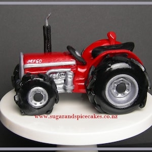 May include: A red toy tractor with black wheels and a silver grill. The tractor has the words "MF60" on the hood.