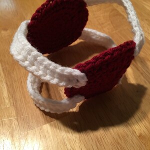 Puede incluir: Orejeras de ganchillo hechas a mano en rojo y blanco. Las orejeras son de color rojo intenso, y la diadema es blanca. El hilo texturizado crea un accesorio c&aacute;lido. Perfectas para el fr&iacute;o, estas orejeras ofrecen estilo y comodidad. Circunferencia de unos 40 cm.