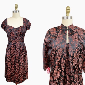 May include: A black and red brocade dress with a sweetheart neckline and short sleeves, paired with a matching black and red brocade jacket with a mandarin collar and long sleeves.