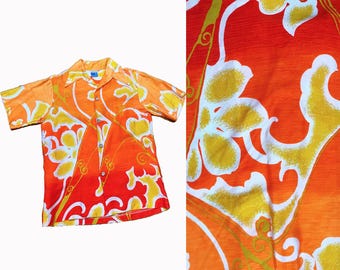 May include: Orange and yellow short-sleeved button-up shirt with a floral pattern. The shirt has a gradient effect, fading from orange to yellow.