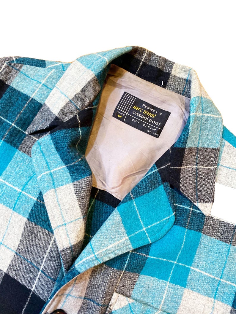 May include: A blue, black, and white plaid casual coat with a label that reads "Penney's 100% wool casual coat, size M, dry clean".