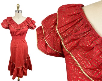 May include: A red dress with gold trim and a ruffled neckline and hem. The dress is made of a lightweight fabric and has a fitted bodice and a full skirt.