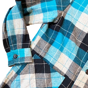 May include: A blue, black, and gray plaid flannel shirt with a patch pocket on the left side.