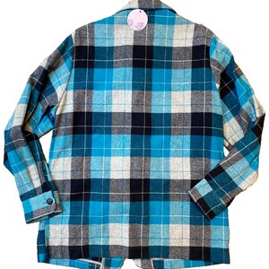 May include: A blue, black, and white plaid flannel shirt with long sleeves and a button-up front.