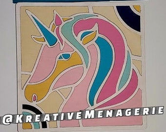 May include: A colorful stained glass style unicorn head with pink, blue, and yellow accents. The image includes the text "@Kreative Menagerie".