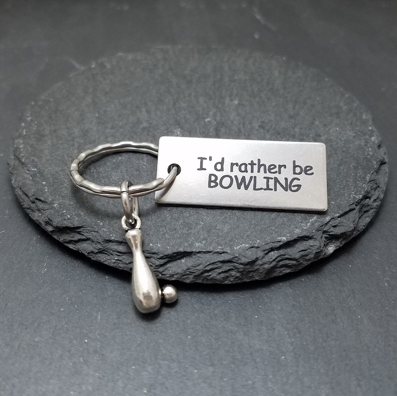 May include: Silver keychain with a bowling pin charm and a tag that reads "I'd rather be bowling".