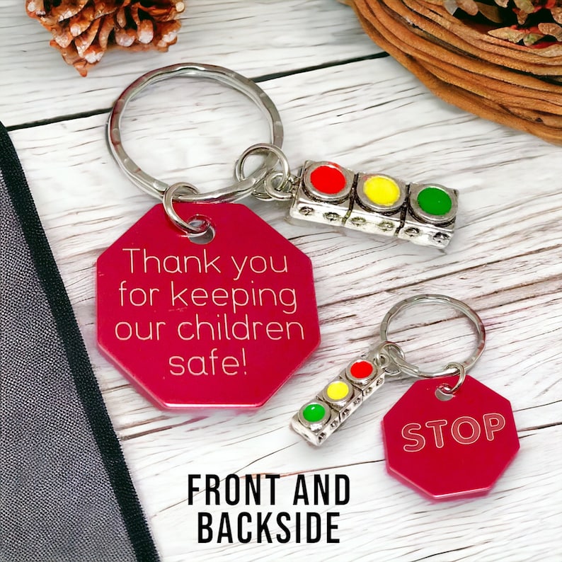 May include: Red and pink octagonal keychain with the text "Thank you for keeping our children safe!" on one side and a traffic light charm. The other side of the keychain is red and has the word "STOP" on it.
