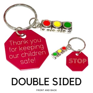 May include: Double-sided red stop sign keychain with a silver traffic light charm. The front side of the keychain says "Thank you for keeping our children safe!" and the back side says "STOP".