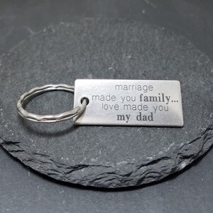 May include: Silver keychain with a rectangular tag that reads "marriage made you family... love made you my dad".