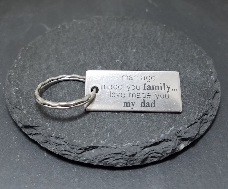 May include: Silver keychain with a rectangular tag that reads "marriage made you family... love made you my dad".