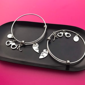 May include: Two silver charm bracelets with heart charms that say "Part in Crime" and "Ners in Time" and other charms including handcuffs and letters.