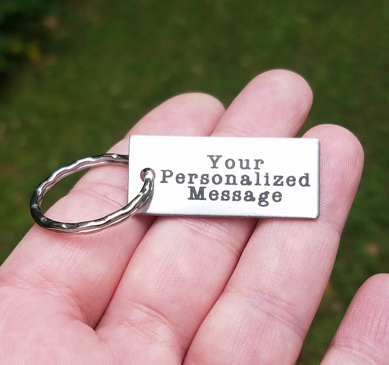 May include: A silver keychain with a silver ring and a rectangular tag that says "Your Personalized Message".