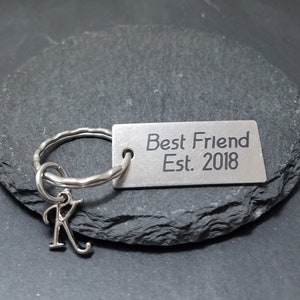 May include: Silver keychain with a charm that says "Best Friend Est. 2018" and a small letter K charm.