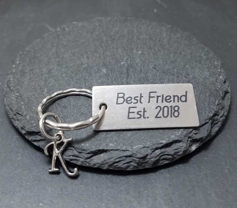 May include: Silver keychain with a charm that says "Best Friend Est. 2018" and a small letter K charm.