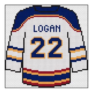 Könnte beinhalten: Ein gesticktes Hockey-Trikot in Weiß, Blau, Gold und Rot. Das Trikot trägt den Namen "LOGAN" über der Nummer "22". Die Ärmel und der untere Saum haben blaue und goldene Streifen. Der Kragen ist blau mit einem roten Streifen.