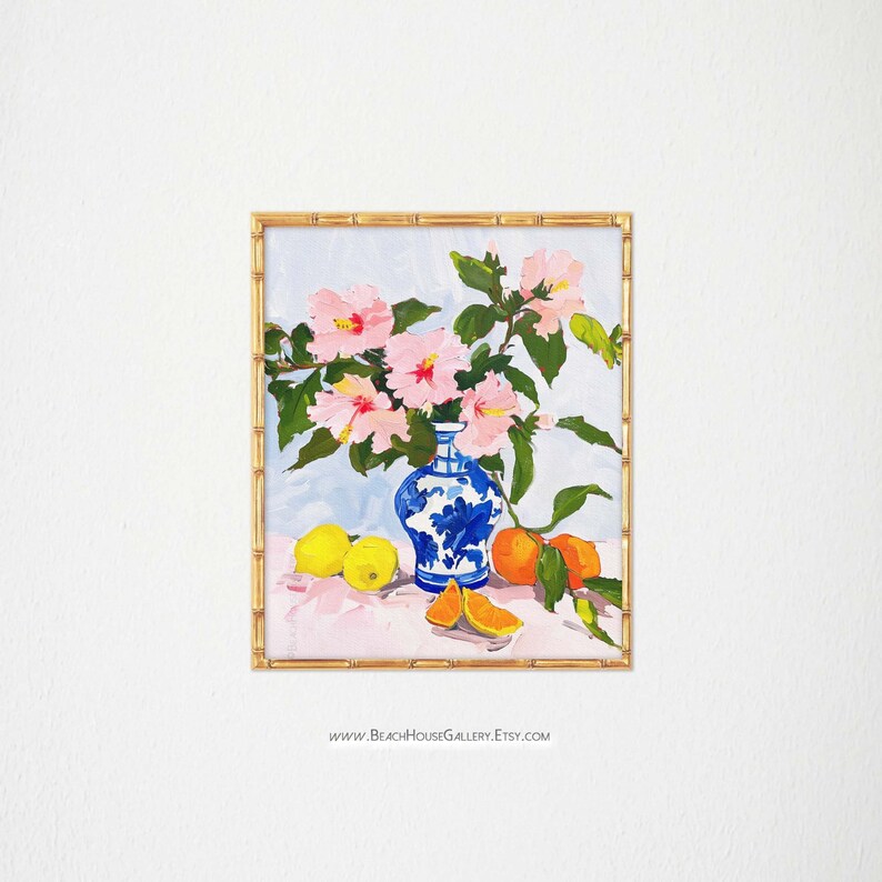 May include: A painting of a blue and white porcelain vase filled with pink hibiscus flowers. The vase is sitting on a table with lemons and oranges.