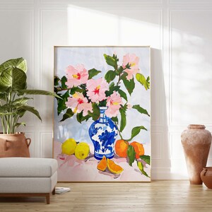 May include: A painting of a still life featuring a blue and white porcelain vase filled with pink hibiscus flowers, lemons, and oranges on a pink tablecloth.