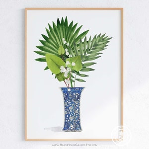 K&ouml;nnte beinhalten: Ein Aquarellbild einer blauen und wei&szlig;en, gemusterten Vase mit gr&uuml;nen Bl&auml;ttern und wei&szlig;en Bl&uuml;ten. Die Vase steht auf einem wei&szlig;en Hintergrund.