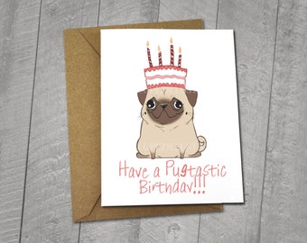May include: A birthday card featuring a cartoon pug wearing a pink and white birthday hat with candles. The card has the text "Have a Pugtastic Birthday!!!" printed on it. The card is 5x6.5 inches and comes with a 5x7 inch envelope.