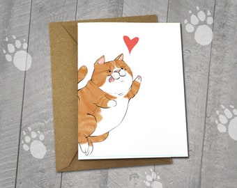 May include: A blank greeting card featuring an original illustration of a cartoon orange tabby cat reaching up for a red heart. The card measures 5x6.5 inches and comes with a 5x7 inch envelope.